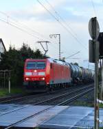 Nach einem Regenschauer kommt die 185 190-6 mit einem Tankwagenzug an den BÜ Dahler Weg in Wickrath herangefahren.