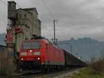 185 090-8 zieht einen Schiebewandwagenganzzug kurz nach der Abfahrt im Bahnhof von Buchs (SG) am 15.11.2014 am alten Fabrikgebude der ehemaligen Basaltstein AG vorbei.