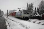 185-675 von Railpool durchfhrt im Schneegestber die Ortschaft Chemnitz Grna mit einem Container Ganzzug. 30.11.2012