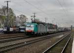 186 225 mit einem KLV am 24.11.2012 bei der Durchfahrt in Kln West. Im Hintergrund war 182 526 mit einem HKX abgestellt.