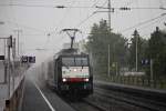 Durchfahrt am 30.07.2014 bei strömenden Regen von SBB Cargo ES 64 F4-990 mit einem Containerzug in Müllheim (Baden) gen Basel.