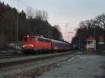 Die 110 438 am 26.02.2011 mit einem Turnuszug bei der Durchfahrt in Aling.