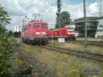 110 0169-0 am Prellbock, das 3 kpfige Personal steigt aus,
um eine grere Pwise beim Bcker im Bahnhof zu machen.
Dahinter ein RE nach Braunscfeihkeig mit einer 146.1