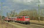 111.036 fährt am 27.02.2014 ohne Halt durch den Bahnhof Assling in Richtug Salzburg. Dabei wird ein am Bahnsteiggleis wartender Güterzug überhohlt.