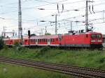 112 133 fhrt gerade mit einer Wagenberfhrung, bestehend aus einigen Steuerwagen und einem Mittelwegen, in den Bereich des Hbf Stralsund ein.