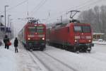 Whrend 145 077-4 versucht den Gterzug aus dem Schnee zu ziehen, fhrt der RE3 mit 114 026-8 nach Elsterwerda in den Bahnhof Baruth(Mark) ein.