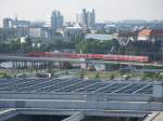 Von der Gre her wie auf einer Modellbahn. Ein RE mit einer 143 oder 112 auf der Stadtbahn in Berlin. Fotografiert vom Reichstag. Im Hintergrund: Die Berliner City