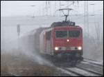 155 256-1 kämpft sich mit einer arbeitsscheuen 185er und einem Güterzug nach Rostock-Seehafen am 26.01.2007 in Stralsund durch den Schneesturm.