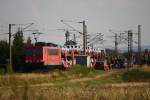 155 113 zieht einen Zug neuer Skodas in Richtung Riesa, hier am Bahnbergang in Jessen, 06.08.09