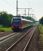 Gegenlichtaufnahme einer S8 die in Bttgen an den Bahnsteig heran fhrt.