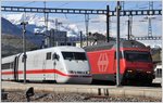 ICE 70 und IC570 mit 460 079-7 vor noch verschneiter Bergkulisse im Bahnhof Chur.