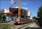 Großbaustelle an der S-Bahnstation -    Ein S-Bahnzug der Linie S6 an der Haltestelle  Neuwirtshaus (Porscheplatz)  mit der Baustelle des neuen Porsche-Museums im Hintergrund.