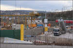 . Abstellbahnhof und Stuttgart 21-Baustelle -

Blick auf den Abstellbahnhof am Rosensteinpark in Stuttgart mit einem Velaro D-Zug. In Bildmitte ist eine Baugrube für einen sogenannten Zwischenangriff für neue Bahntunnels zu sehen. Östlich meines Standpunktes unter dem Rosensteinpark werden sich der neue S-Bahntunnel und der Fern- und Regionalbahntunnel aus Bad Cannstatt überkreuzen. Diese Kreuzung wird entgegen ursprünglicher Pläne bergmännisch gebaut und dazu wurde wohl dieser Zwischenangriff eingerichtet.

Durch das Bahnprojekt Stuttgart 21 wird auch diese Abstellbahnhof verlegt werden müssen und zwar an ein vorhandenes Gleisgelände zwischen Bad Cannstatt und Untertürkheim. Vom neuen Hauptbahnhof aus wird diese neue Abstellanlage ringförmig erreicht werden können, also Hauptbahnhof und Abstellbahnhof liegen dann an einem Gleisring. Möglich wird dies durch zwei Tunnelbauten, einmal durch den Stuttgarter Osten von der Filsbahn zum Hauptbahnhof und durch den hier verlaufenden Tunnel von Murr-, Rems- und nochmals die Filsbahn zum Hauptbahnhof auf der anderen Seite.

Auf dem Gelände des jetzigen Abstellbahnhofes wird dann Wohnbebauung entstehen, in schöner Lage zu den Parks.

04.03.2017 (M)