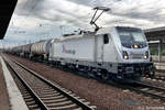 RheinCargo E-Lok mit Kesselwagen den Bahnhof Berlin Schönefeld Flughafen westwärts durchfahrend.