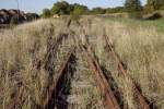 Offengelassene Wagenübergabestelle eines Industrieanschlussgleises an der Rinteln-Stadthagener Eisenbahn in Obernkirchen. Anders als die Staatsbahnen hatte diese regelspurige Kleinbahn eine besondere Vorliebe für Dreiwegweichen, wie hier im westlichen Kopf der Wüst. Die Wüst wurde beidseitig als Spitzkehre angelegt, da zwischen dem Bahnhof Obernkirchen und dem angeschlossenen Werk auf kurzer Entfernung ein deutlicher Höhenunterschied bestand. 29.09.2013