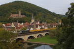 Abraumzug, der Bauz 83453 mit Vectron in schwarz auf der Saalebrücke in Gemünden am Main mit Burgruine Scherenburg, dem Turm der alten Stadtmauer und die Parrkirche im Hintergrund.