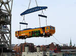 Gesehen während unserer Hafenrundfahrt vom Schiff aus: Fliegende Baumaschine, am Kran hängend. Hamburg, 31.3.2022