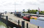 Am 03.07.2021 ist die Lok  Aurich  mit abreisenden Urlaubern im Borkum Reede angekommen, im Hintergrund lugt die AG Ems-Fähre  Groningerlanden  nach Eemshaven/Niederlande zwischen den