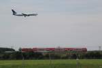 Der von einer 143 geschobene RE 26031 und eine 767 von Ryan International Airlines am 9.8.2009 im Anflug auf den Flughafen Leipzig/Halle.