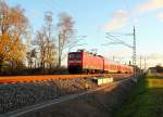 Die 112 119 mit dem RE 4360 nach Rostock Hbf bei der Durchfahrt am 25.11.2013 in Nassenheide.