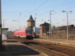 RE17122 (Leipzig - Hoyerswerda) fhrt vorbei am etwas arg gelittenen Wasserturm im Bf Ruhland. 24.03.06