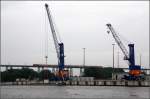 Hafenkräne vor Bahnbrücke -    Rendsburger Hochbrücke und der Nord-Ostsee-Kanal.