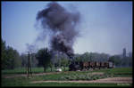 Am 3.5.1990 ist hier 991542 mit einem Leerzug Kaolin Wagen entlang der Landstraße kurz vor Mügeln unterwegs.