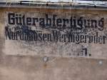 Eine alte Anschrift an einem Gebäude im Bahnhof Nordhausen, aus einer Zeit als die Harzer Schmalspurbahn noch Nordhausen Wernigeröder Eisenbahn (?) hieß.
