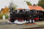 Wasserfassen von 99 5901 vor IG HSB-Sonderzug am 17.10.2015 im Bahnhof Benneckenstein. (Bild 1)
 So, dann woll`n wir mal!  Kräftig dreht der Lokheizer am Handrad, um den Absperrschieber des Wasserkranes zu öffnen.