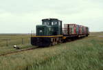 Vollbeladen fährt die Lokomotive  Karl  (Deutz 1951/47165) der Juister Inselbahn im Mai 1981 vom Anleger zum Ortsbahnhof. Neben den Passagieren transportierte die Inselbahn auch die Güter des täglichen Bedarfs vom Schiff in den Ort. Die Lok wurde 1966 von der stillgelegten Herforder Kleinbahn gekauft und gehört heute der Märkischen Museums-Eisenbahn.