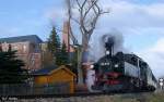 99 516 mit Personenzug auf Osterfahrt, Museumsbahn Schnheide, fotografiert bei Ausfahrt Sttzengrn mit Brstenfabrik im Hintergrund am 17.04.2006