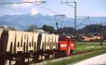 Vor der Kulisse der Tiroler Berge bringt eine Lok der Wachtlbahn im Juni 1999 Material aus dem Steinbruch nach Kiefersfelden, hier kurz vor Kohlstatt