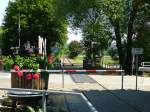 Deutschland, Rheinland-Pfalz. Auf der stillgelegten Bahnstrecke Staudernheim - Lauterecken - Altenglan kann man im Sommer mit gemieteten Fahrraddraisinen das Glantal erkunden. Die Draisinen halten an diesem Bahnübergang in Raumbach an, öffnen die Schranken und setzen die Fahrt fort.03.07.2014