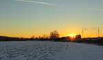 Nachschuß auf einen DB Güterzug während die Sonne untergeht bei Unterlangenstadt am 20.01.2017.