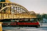 Von der Abendsonne angestrahlt zeigt sich die Hackerbrcke in Mnchen Hbf, whrend ein Regional Express mit Br 218 ausfhrt.