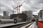 . Von der Brücke in den Tunnel -

Da die Stadtbahnbrücke auf der einen Seite jetzt für Fußgänger und Radfahrer freigegeben ist kann die neue Stadtbahnstation Budapester Platz auch von dieser Seite her gezeigt werden. Dahinter das Europaviertel, das im Bereich des früheren Güterbahnhofes im Entstehen begriffen ist. Die Haltestelle liegt auf der Brücke, danach fahren die Stadtbahnen in eine neue Tunnelstrecke die kreuzungsfrei in die ebenfalls neugebauten Röhren zwischen Hbf (Arnulf-Klett-Platz) und Stadtbibliothek einmünden. Der alte Stadtbahntunnel ist den Gleisen des neuen Hauptbahnhofes im Weg und musste deshalb in tieferer Lage neu gebaut werden.

13.06.2016 (M)
