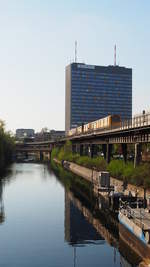 Auf der U1/U3 fährt hier zwischen  Möckernbrücke  und  Hallesches Tor  ein 3/4-Zug mit Ziel  Warschauer Straße . Im HIntergrund ein Hochhaus einer Versicherung.
Aufgenommen von der Mehringbrücke.

Berlin, der 07.04.2019.