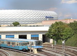 Zwei ältere Garnituren der U-Bahn München stehen in der Basis Fröttmaning im Münchner Stadtteil Freimann und warten auf ihren nächsten Einsatz. Im Hintergrund ist die Allianz Arena des FC Bayern München zu sehen.
München Fröttmaning, 11. August 2016