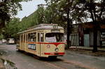 Der GT 6 2420 der Rheinbahn kommt Ende der 1970er Jahre an der Haltestelle Merowingerplatz an. In den ersten Jahre nach Einführung des schaffnerlosen Betriebes wies ein stilisiertes weißes  S  auf rotem Grund die Fahrgäste darauf hin, dass Fahrscheine beim Fahrer gelöst werden mussten.