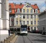 Die Straßenbahn im Stadtbild von Augsburg -     Hier kommt eine Combino-Straßenbahn am Dom um die Ecke, umgeben von historischer Bebauung.