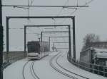 Ein Combino auf der Linie 5 nach Erfurt Hauptbahnhof berquert die Eisenbahnberfhrung in Erfurt Nord. 23.2.2013