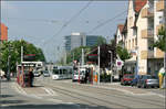 Durch Freiburg-Haslach ins Rieselfeld -

Die Haltestelle 'Dorfbrunnen' in Haslach. Die GT8Z-Tram kommt nicht aus einer Seitenstraße sondern schlängelt sich aus dem eigenen Bahnkörper entlang der Opfinger Straße in die Straßenmitte Carl-Kistner-Straße. In der Ortsdurchfahrt von Haslach wurde eine Einfachfahrleitung verwendet, die erfreulicherweise meist an den Gebäuden aufgehängt wurde, so entfallen störende Masten.

11.05.2006 (M)