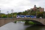 Ein Straßenbahnzug der Linie 7 am 05.10.2011 auf der Giebichensteinbrücke über die Saale. Unterhalb der Brücke ist die Anlegestelle der Saale-Fahrgastschifffahrt am Rive-Ufer zu sehen, direkt unterhalb der bekannten Burg Giebichenstein.