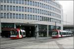 Unter und neben dem Gebäude -    Straßenbahnverkehr nahe der Haltestelle Berliner Platz in Ludwigshafen.