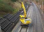 Ein Schienenbagger hat gerade neue Betonschwellen ins Gleisbett gesetzt und fhrt nun Nachschub holen. Aufgenommen im Dez. 07 von einer Bahnbrcke bei Reinfeld (Holst.).
