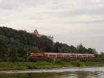 Ein S-Bahnzug, aus Dresden kommend und mit Ziel Schna, passiert am 30.08.2012 gerade das in Pirna gelegene Schlo  Sonnenstein . Die Aufnahme entstand vom Personendampfer  Meissen  auf der Elbe aus.