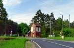 Auf den ersten Blick könnte man glauben, an der einsam im Wald neben der Bundesstraße 246 stehenden Blockstelle Reetz sei alles in bester Ordnung. Bei genauerem Hinsehen zeigt sich, dass die Schrankenbäume bereits abmontiert und die Schienen der zweigleisigen elektrifizierten Hauptbahn rostig sind. Das Foto entstand am 20.05.2005 – zu einem Zeitpunkt, als die Strecke Güterglück–Wiesenburg (Mark) bereits seit gut einem halben Jahr stillgelegt war.