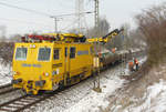 27. Januar 2010, Zwischen Hochstadt und Küps werden neue Masten für die Fahrleitung gesetzt. Der MTW brachte den Flachwagen mit den neuen Masten und hebt einen davon mit seinem Kran auf den Sockel. (Wir haben -15°C!)