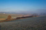 Aus dem Nebel heraus fährt 247 052 mit einem Kesselzug bei Thann-Matzbach in Richtung München, aufgenommen am 30.