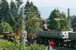 Bei Lindau wurde ein Teilstck des ins Allgu hinauffhrenden Gleises erneuert. Beim Ausbaggern und Ausschtten des alten Gleisschotters in einen Schttgutkippwagen der Gattung Uas (33 54 9300 150-7 CZ-SPAG) war auf Grund der Oberleitung der Bewegungsraum fr den Baggerarm begrenzt. Da kam es einmal vor, dass der Baggerarm die Oberleitung berhrte und dadurch die Auslegerarme der Oberleitungsmasten zum Schwingen brachte. Bodolz, am Hoyerberg, 10.08.2020